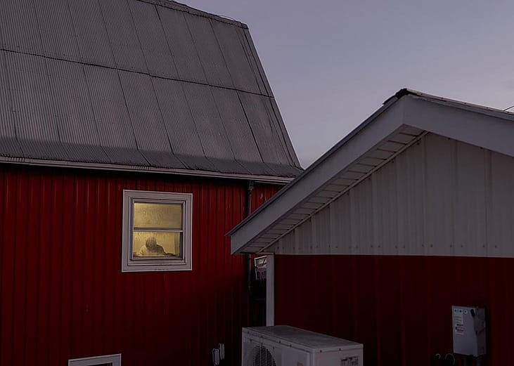 A worker can be seen by the window of one of the dairy farm properties at Pleasant Valley Farms in Vermont.