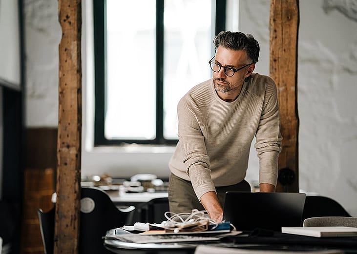 A businessman working from his laptop in an office.