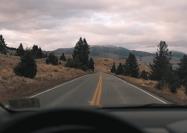 A scenic highway with a mountainous terrain in the distance.