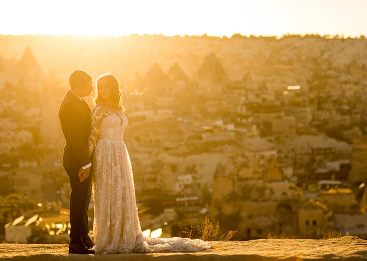 A couple poses for a sunset wedding photograph in their venue in Cappadocia, Turkey.