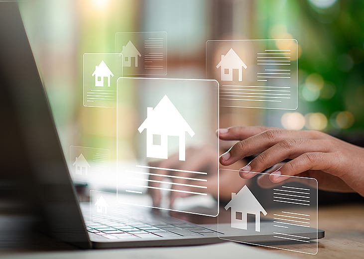 Digital real estate listing graphics over an agent using a laptop.