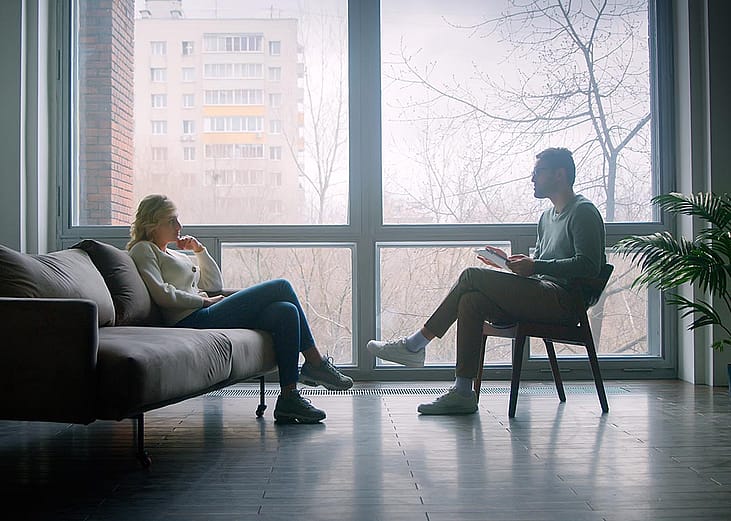 A doctor and a patient undergoing through a therapy session indoors.