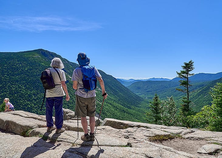 Hikers looking at the scenic view of the Crawford Notch from Mt. Willard in Carroll Country, New Hampshire, USA.