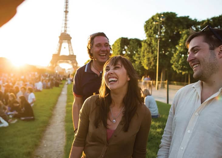 A group of friends enjoying an afternoon outdoors in front of the Eiffel Tower in Paris, France.