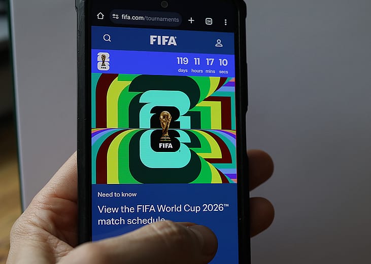 Person scrolling through a FIFA World Cup 2026 news article on a phone.