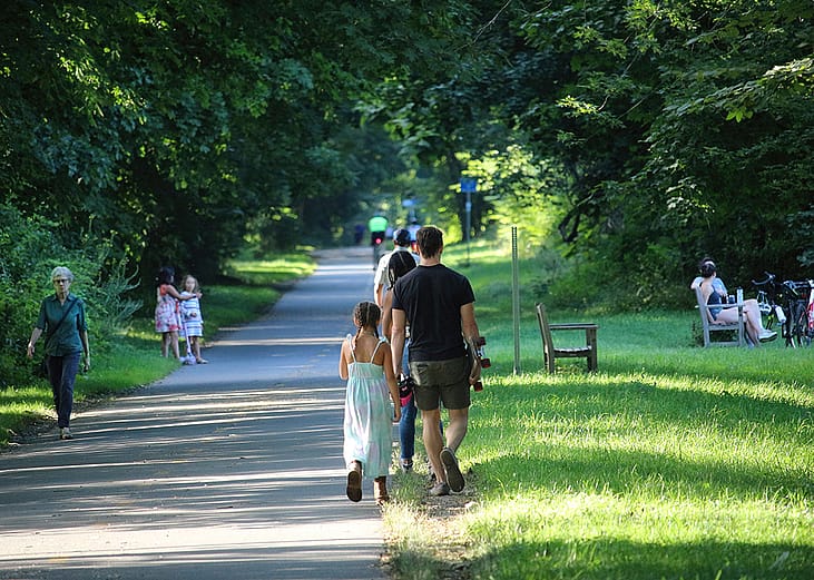 People walking and sitting along Minuteman Bikeway, Massachusetts, USA.