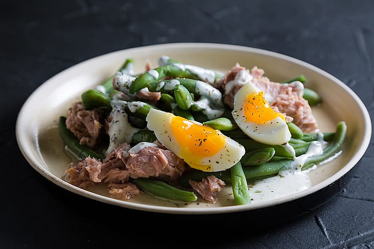 A tuna and green bean salad with boiled egg.