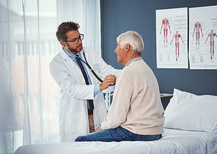 A doctor assessing an elderly person's breathing with a stethoscope during a medical check-up.