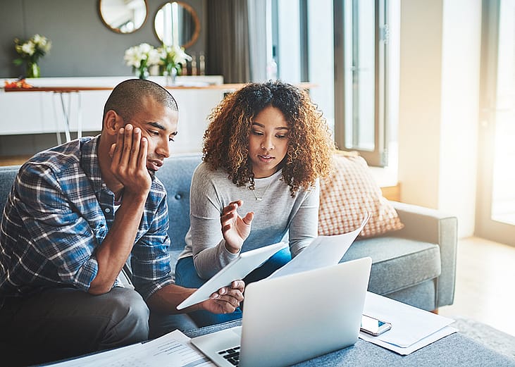 A young couple calculating expenses at home.