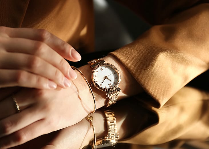 A person wearing a luxury wristwatch over a mirror. 