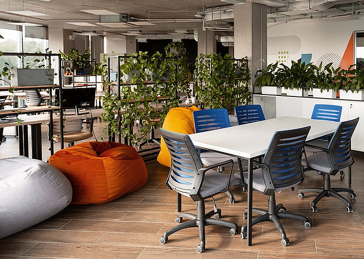 Comfortable beanbag chairs and lush greenery at a modern coworking space.
