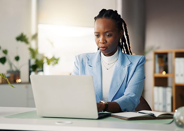 An office employee proofreading a work task before publication from her laptop.