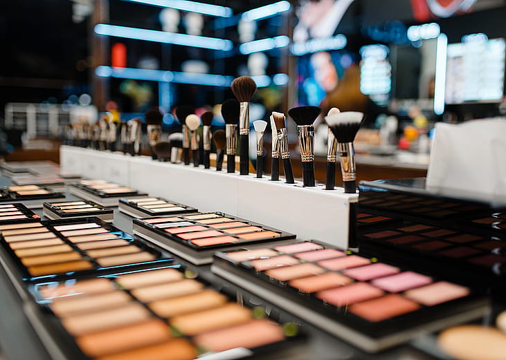 Close up shot of brushes and makeup palettes in a cosmetics store.