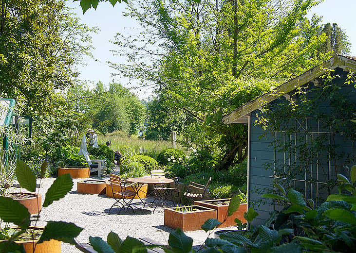 A lovely garden space with outdoor seating area and a garden shed.