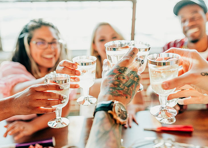 A group of friends toasting their drinks together during a celebration.