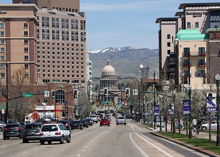 A view of the Idaho state capitol building downtown with overlooking mountains at the back.