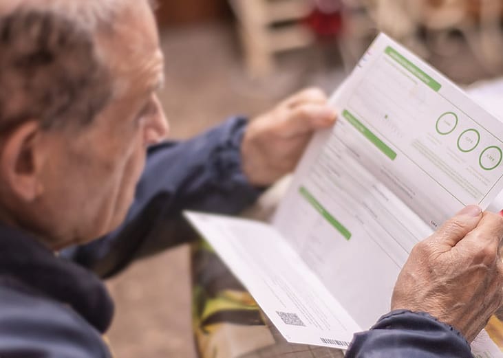 An elderly man reviewing his electricity bill.