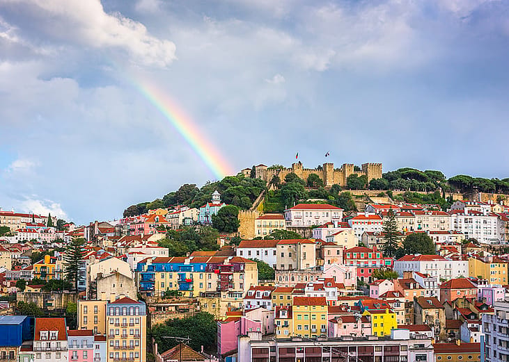 A rainbow seen over the Sao Jorge Castle and Lisbon skyline in Portugal.