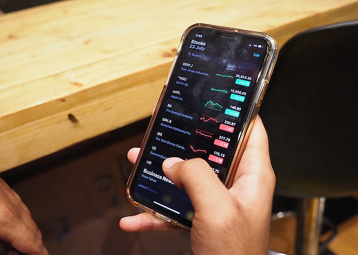 A person checking the stock market from an iPhone.