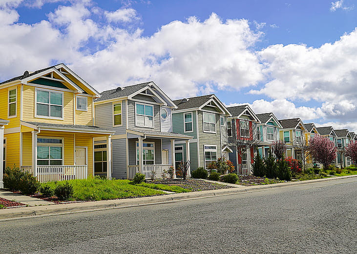 A row of colorful family homes in a residential neighborhood.