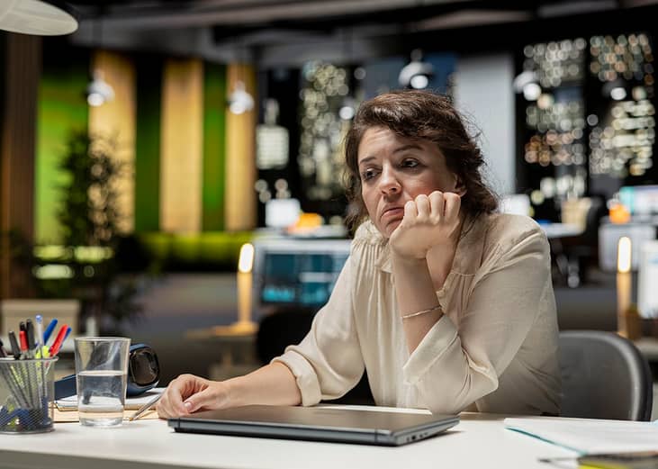 A demotivated businesswoman working late at night.