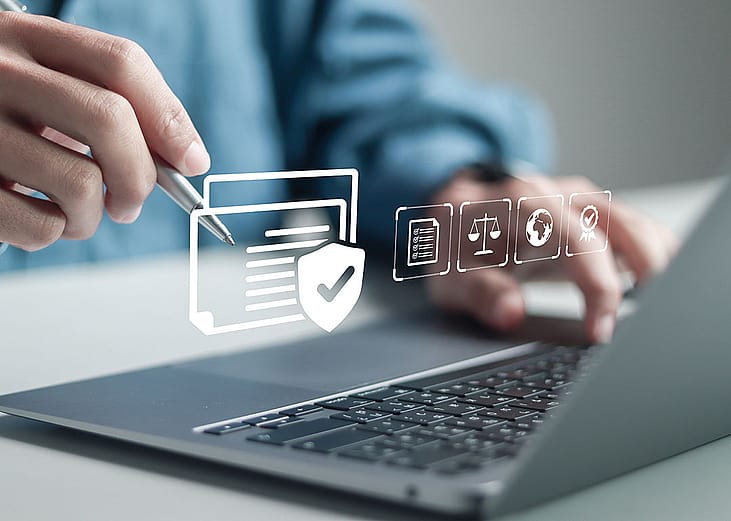 Businessman using a laptop illustrated with compliance software graphics.