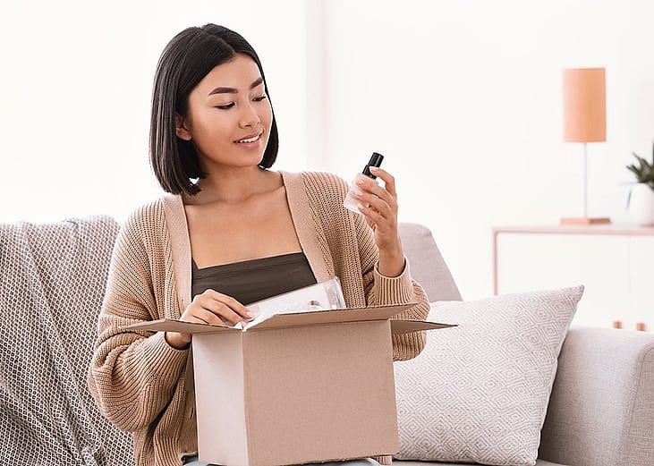 A young woman unboxing a package of makeup delivery.