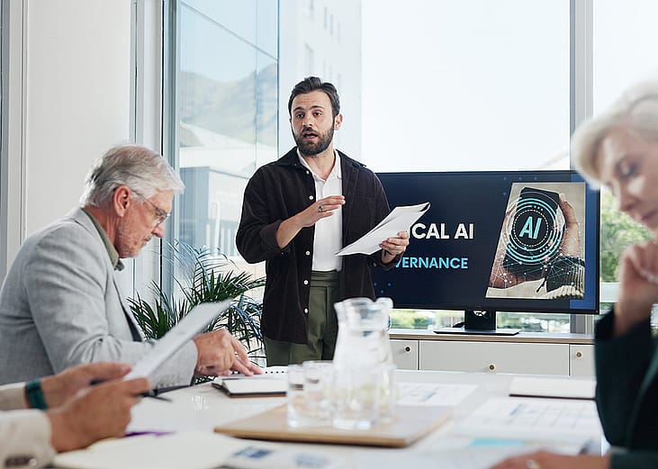 An IT developer presenting AI governance topic during an office meeting.