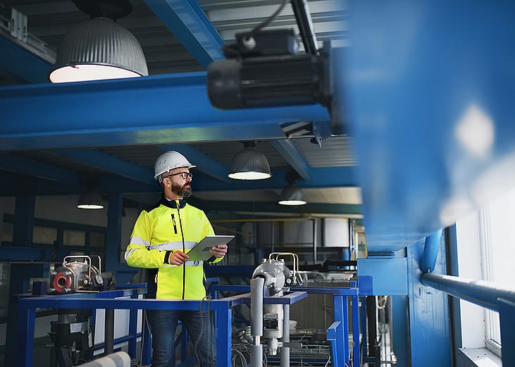 An engineer checking pipes inside an industrial factory.