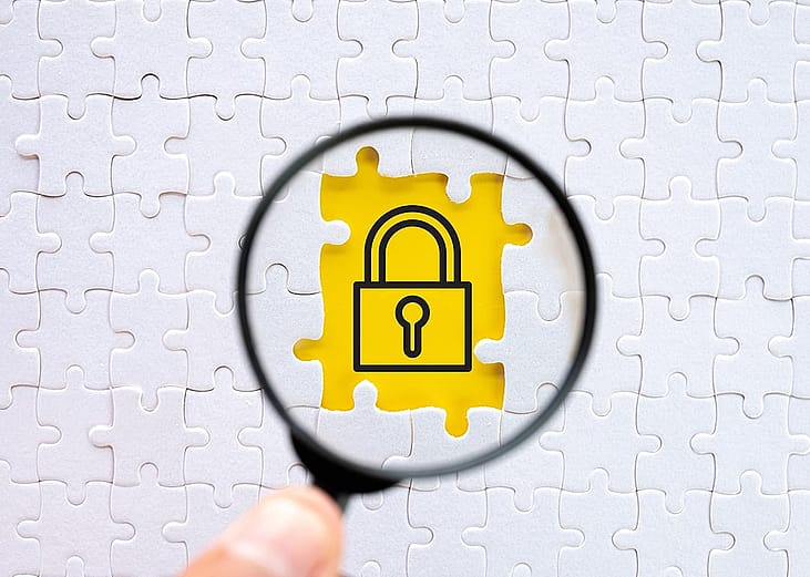 A magnifying glass focused on a padlock icon image in a puzzle.