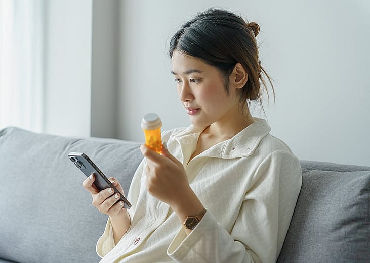 A person checking information about a prescription medicine from her smartphone.