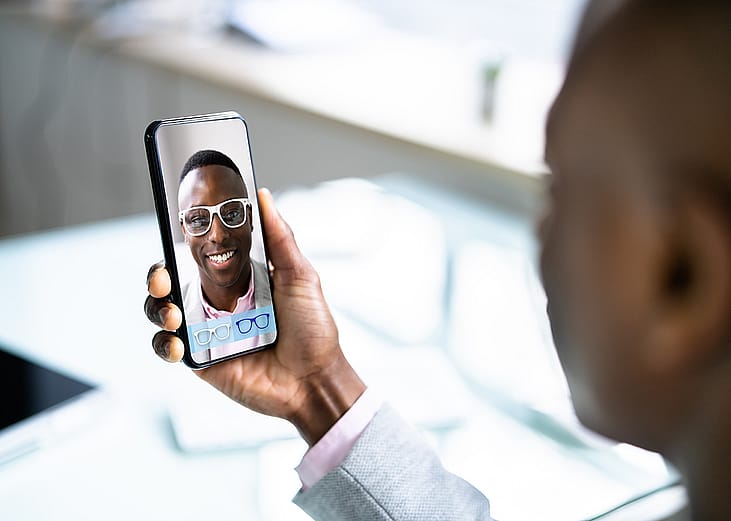 A person checking on virtual eyeglasses from an optical shop's (augmented reality) AR application online.