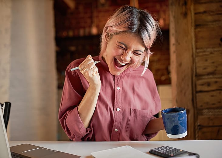 A young adult appearing to be overjoyed after finally paying off debts. 