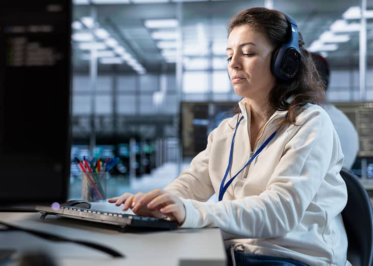 A female programmer listening to music while working in an office.