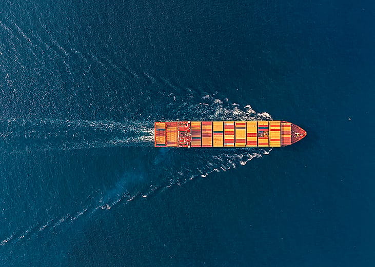 Aerial view of a large cargo ship traveling at sea.