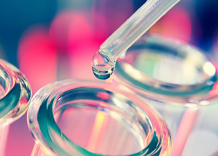 A close up shot of liquid being added into a test tube.