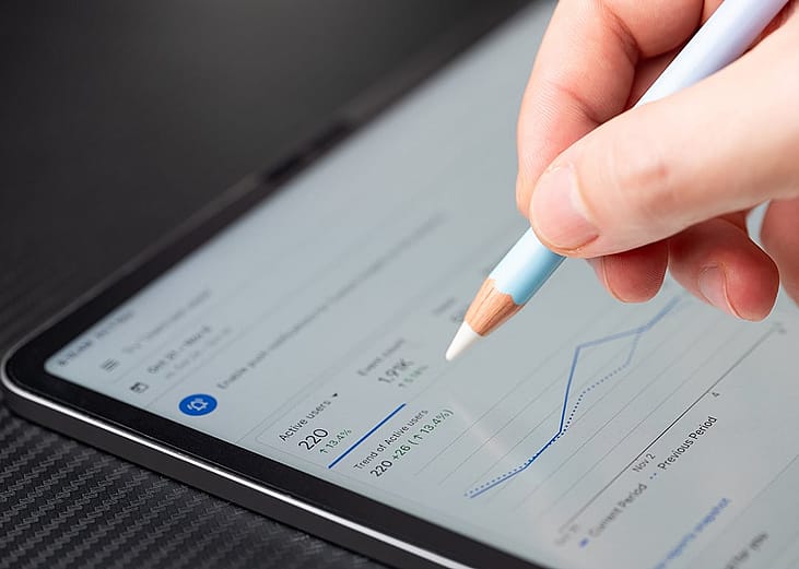 Person navigating Google Ads analytics dashboard on a tablet.