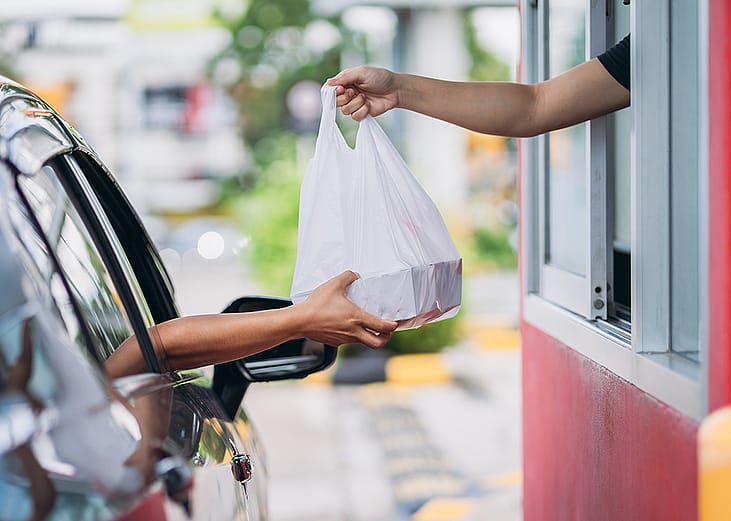 Person receiving their takeaway order at the drive thru.