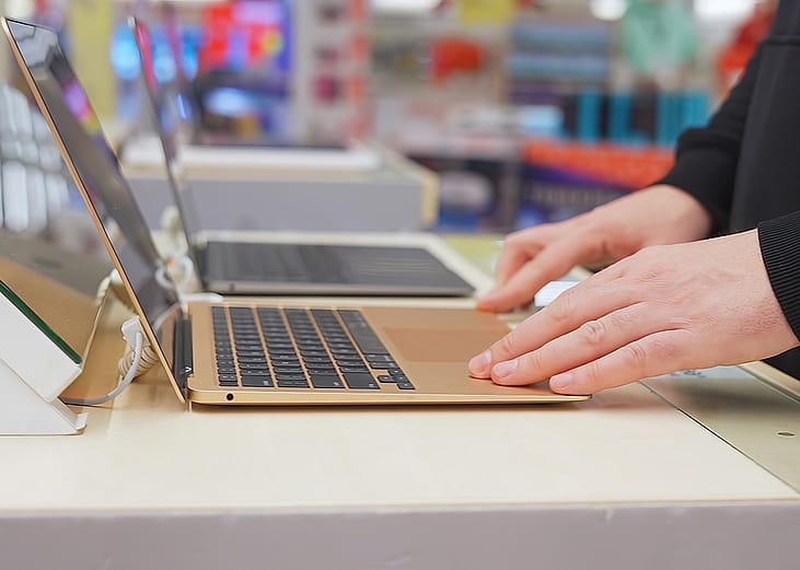 A student testing a brand new laptop at a store.