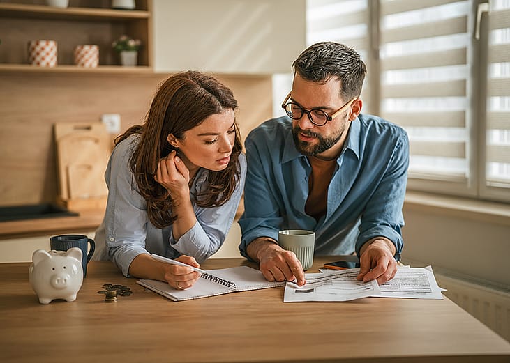 A couple reviewing finances in their home kitchen.