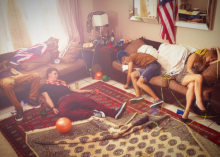 A group of friends in a house drunk and tired after a party.