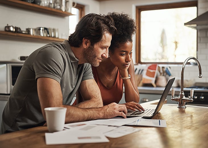 A couple planning finances together in their home kitchen.