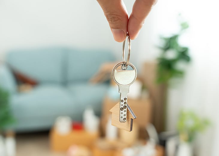 Person holding keys to their house.