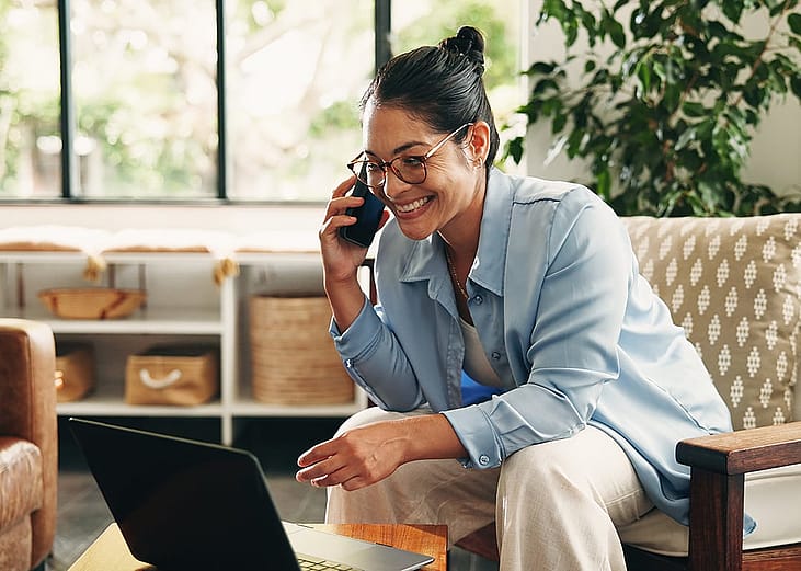A business manager taking a phone call while working remotely at home.