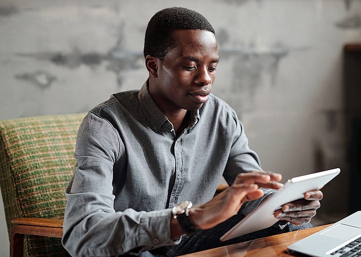 A young businessman browsing information on a tablet.