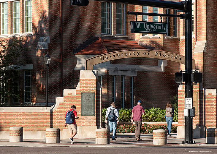 Students walking through an entrance gate at the University of Florida.
