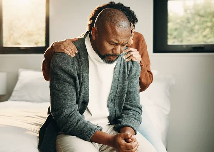 A sad couple comforting each other during a tough time.