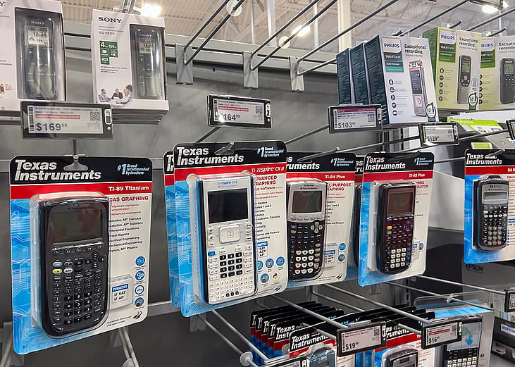 Graphing calculators displayed for sale inside an electronics store.
