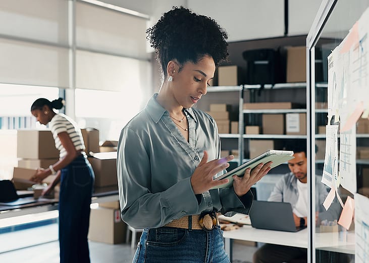 A female employee at a logistics team checking on orders.