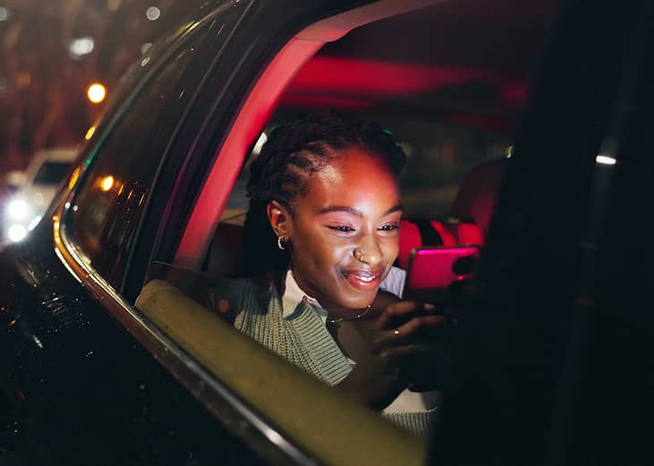 A person happily looking to a message notification from her smartphone. 